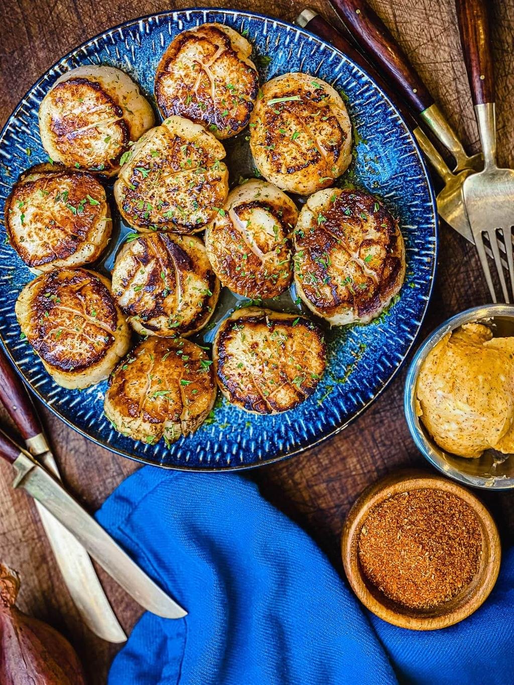Golden brown herb-roasted potatoes arranged on a blue ceramic plate, garnished with chopped parsley