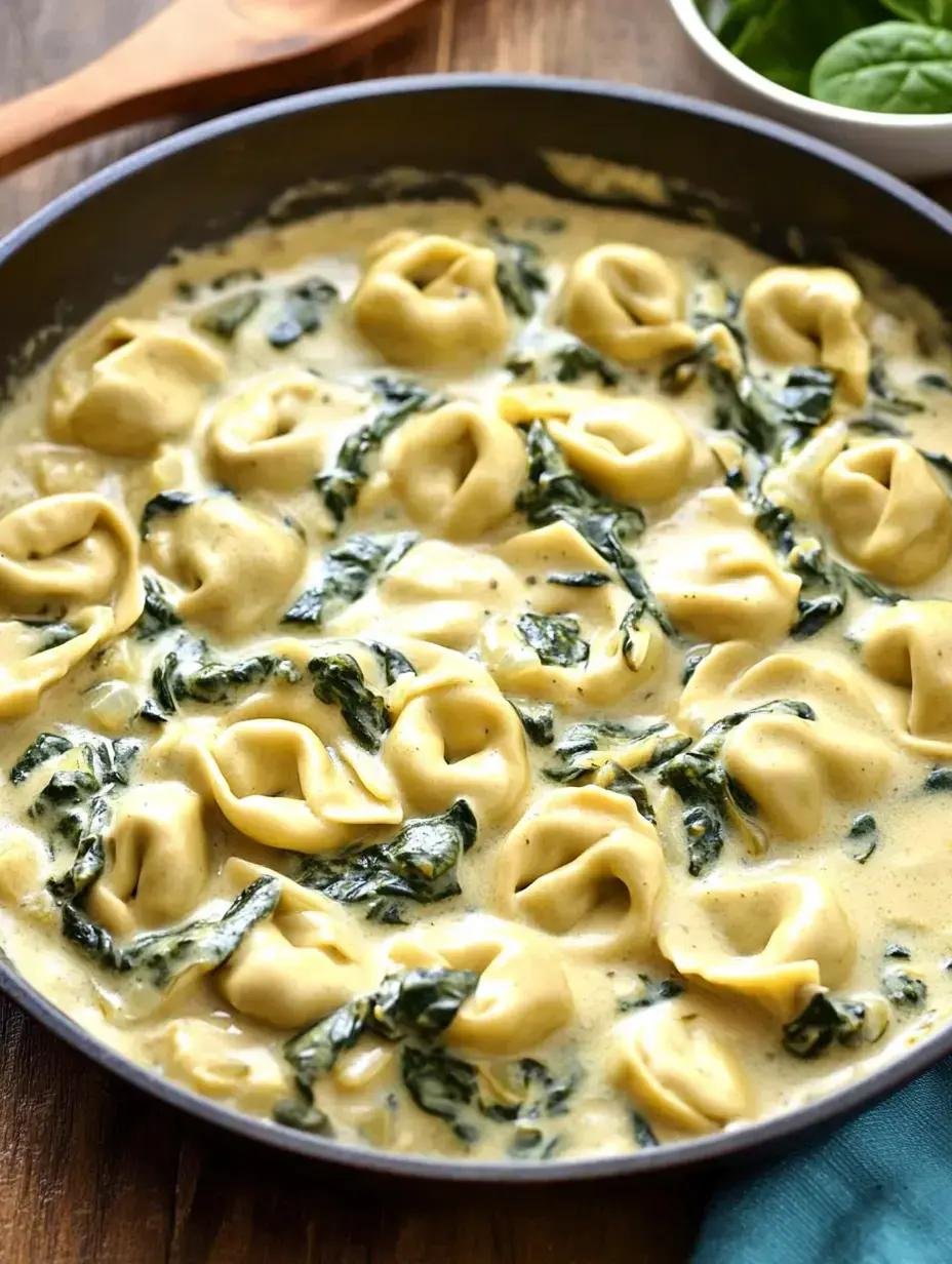 Creamy tortellini with spinach in a skillet, tangy white sauce coating the pasta pieces