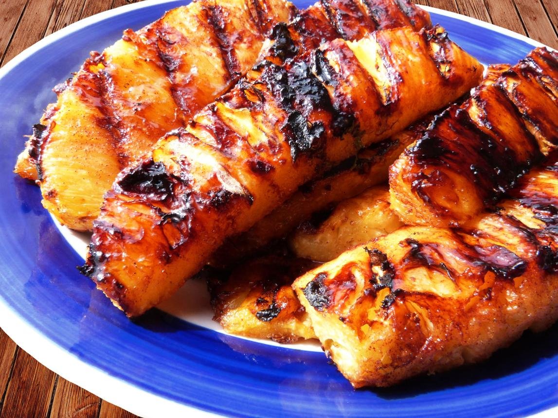 Grilled pineapple slices with caramelized edges on a blue plate.