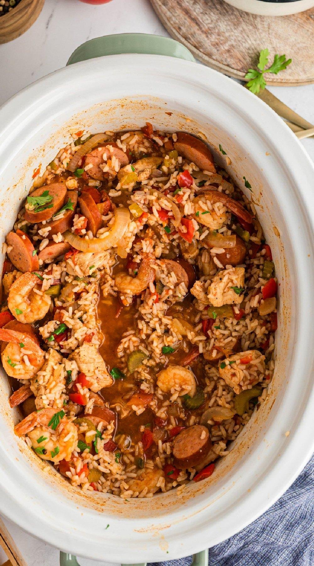 One-pot shrimp and sausage jambalaya with rice, peppers, and onions in a white slow cooker