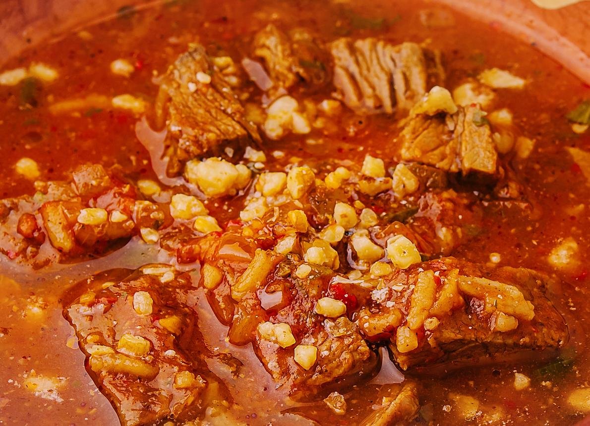 Beef stew in a rich red sauce with corn kernels and tender chunks of beef.