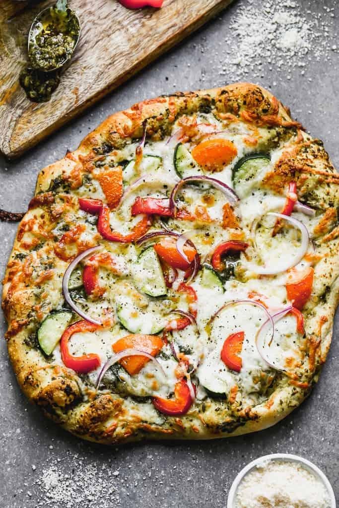 Vegetarian pizza topped with tomato, zucchini, red onion and melted cheese on a crispy crust.