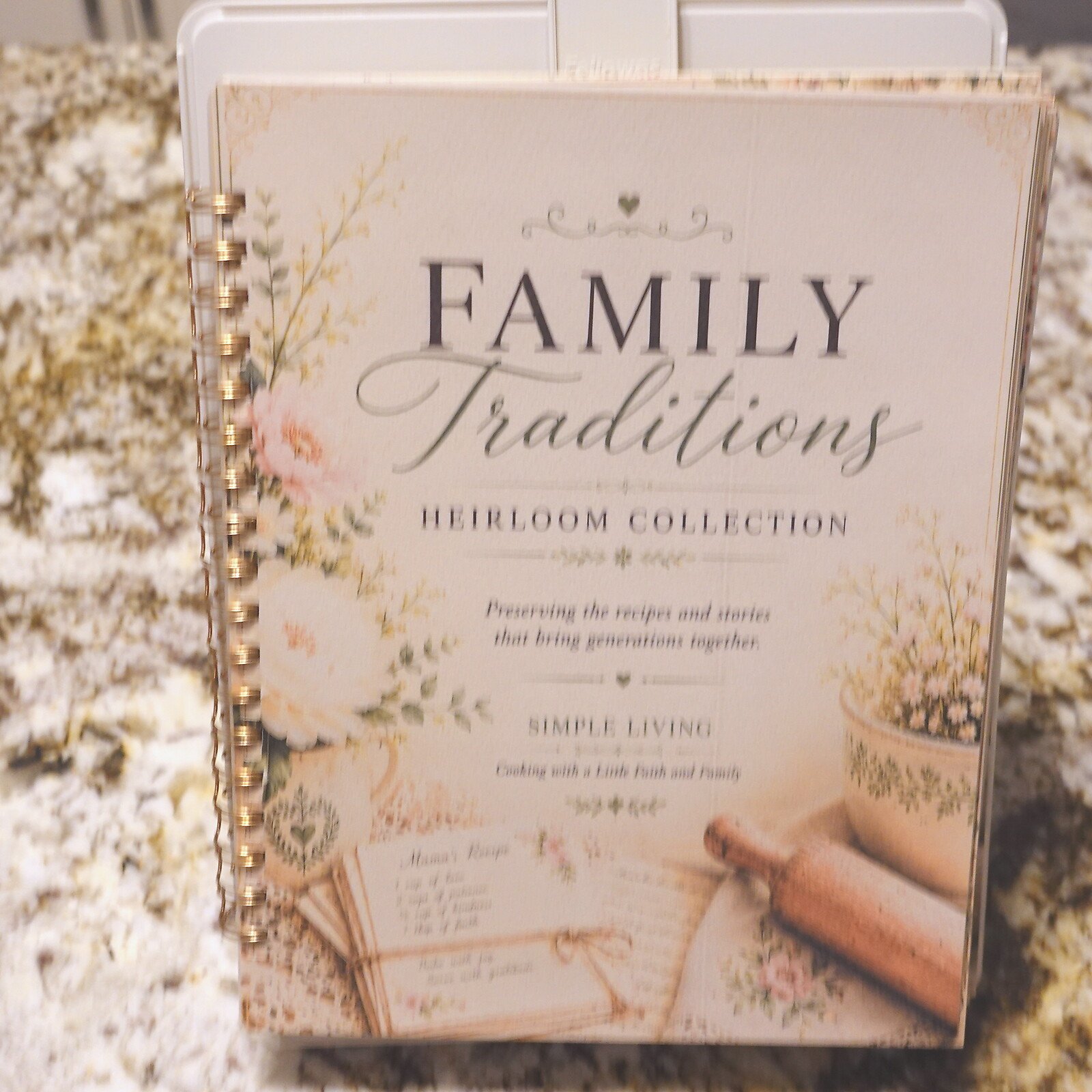 10-standing-lifestyle - Simple Living Faith Close-up of a decorative booklet cover reading 'FAMILY Traditions' with floral accents and 'Heirloom Collection' text below.